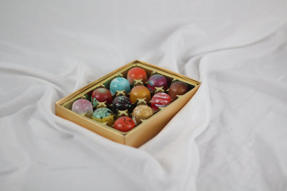 Box of colorful chocolates on a white fabric background