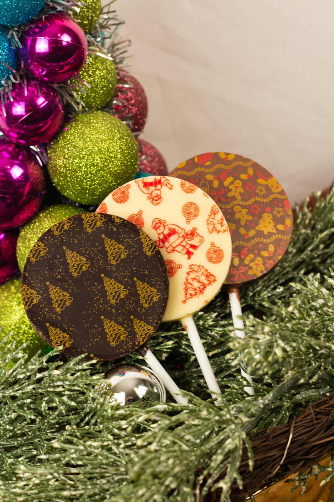 Decorative lollipops with colorful designs on a Christmas tree background