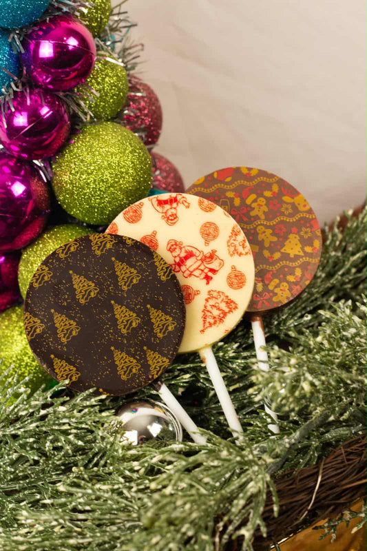 Decorative lollipops with colorful designs on a Christmas tree background