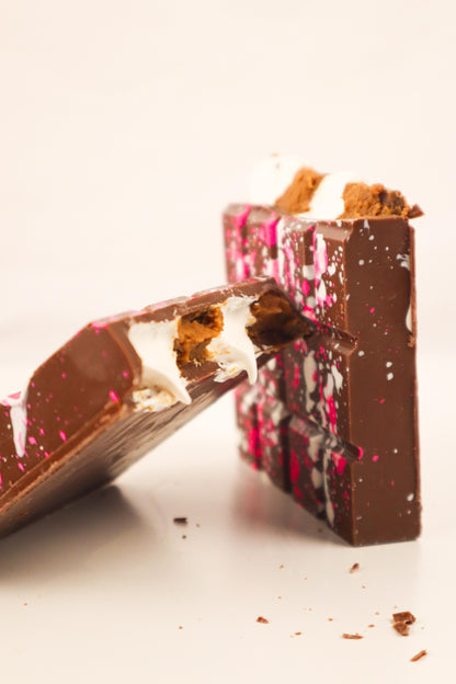 Close-up of a broken chocolate bar with visible layers on a white background