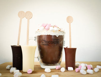 Chocolate drink with whipped cream and marshmallows on a wooden surface